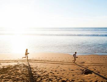 couple of people running on the beach